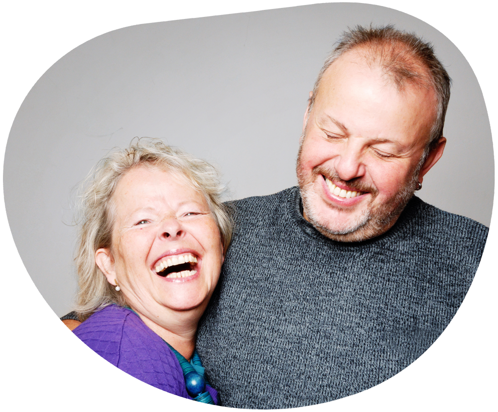 A man and woman embracing each other and smiling affectionately.